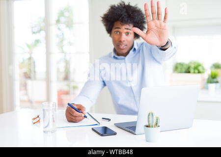 Business Man working écrit sur ordinateur portable avec main ouverte faisant stop avec de sérieux et de confiance, l'expression gestuelle de la défense Banque D'Images