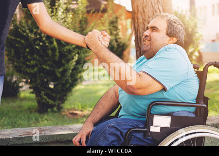 Réunion d'amis dans le parc et faire handshake Banque D'Images