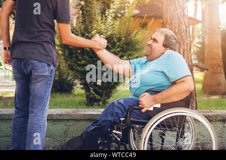 Réunion d'amis dans le parc et faire handshake Banque D'Images