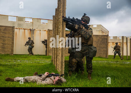 Marines avec Echo, l'entreprise Équipe de débarquement du bataillon, 2e Bataillon, 1er Marines, 31e Marine Expeditionary Unit, l'avance sur l'objectif à long terme au cours d'un raid dans la région centrale de formation, Okinawa, Japon, 14 août 2019. Le 31e Escadron amphibie et MEU 11, à bord des navires du groupe amphibie Wasp, a mené une série d'opérations successives qui simule la force expéditionnaire de la marine à partir de la manœuvre interarmes de la rive, actifs amphibie marine utilisant les capacités du groupe de travail intégré dans tous les domaines de combat. (U.S. Marine Corps photo par Lance Cpl. Kenny Nunez Bigay) Banque D'Images