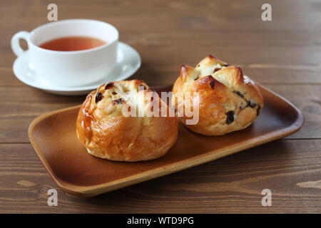 Pain aux raisins avec du thé anglais libre isolé sur le tableau Banque D'Images