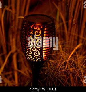 Flamme rougeoyante dans la nuit qui s'étend à la lumière de l'atmosphère. Banque D'Images