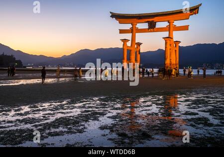 Sanctuaire d'Itsukushima, Torii à marée basse au coucher du soleil, Miyajima, Japon Banque D'Images