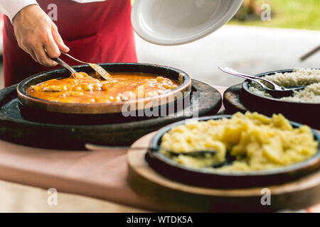 Photo d'un waiter serving poulet parmigiana, du riz et de la purée de pommes de terre. Banque D'Images