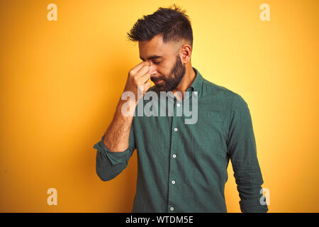 Young indian businessman wearing shirt debout sur fond blanc isolé fatigué se frottant le nez et les yeux sentant la fatigue et les céphalées. Stress Banque D'Images