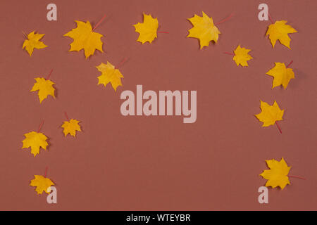 Composition d'automne. Cadre fait de l'automne feuilles d'érable sur fond brun Banque D'Images