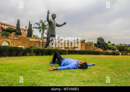 Un jeune homme asiatique Indien reste prise en face de la statue de Nelson Mandela à Pretoria près de la maison du parlement et bâtiments de l'Union européenne Banque D'Images