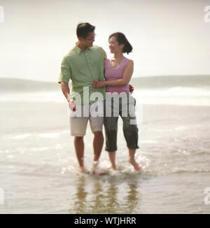 Vue de face d'un couple heureux sur une plage. Banque D'Images