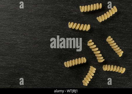 Groupe de huit entiers et frais fusilli bucati pâtes crues copyspace flatlay sur pierre gris Banque D'Images