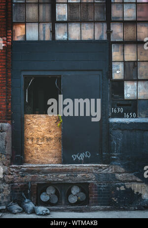 Une porte à bord sur l'extérieur d'un ancien bâtiment abandonné. Banque D'Images