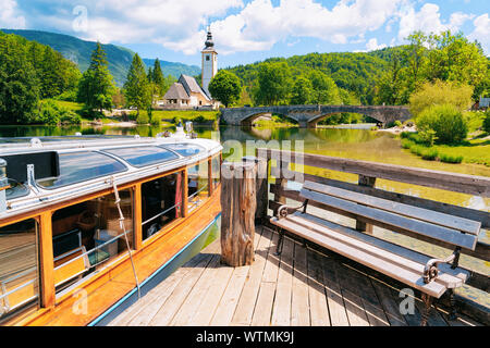 Bateau touristique et banc en bois, lac de Bohinj en Slovénie Banque D'Images