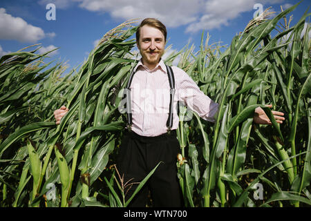 Happy Farmer guy standing dans le maïs Banque D'Images