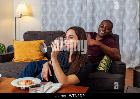 Couple having dinner et regarder la télévision ensemble. Banque D'Images