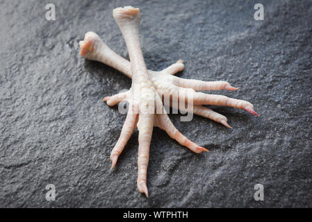 Pieds de poulet sur la plaque noire / pied frais poulet cru pour la cuisson des aliments Banque D'Images