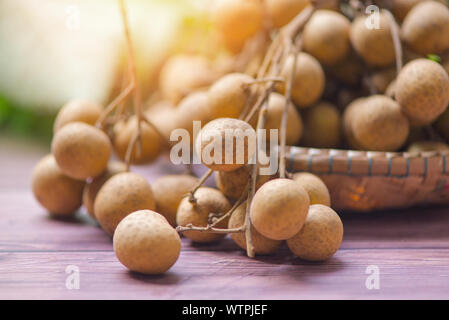 Le longane Dimocarpus longan / panier de fruits sur fond de bois et de la lumière du soleil en été Banque D'Images