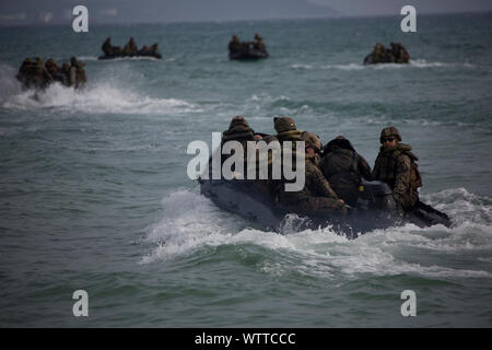 Marines avec Golf Company, l'Équipe de débarquement du bataillon, 2e Bataillon, 1er Marines, 31e Marine Expeditionary Unit, traverse les vagues dans la lutte contre le maraudage en caoutchouc avant d'artisanat un raid amphibie en liaison avec l'insertion d'un système de roquettes d'artillerie à grande mobilité par des engins de débarquement, l'utilité, à partir du dock landing ship USS Ashland (LSD 48) à Kin Bleu, Okinawa, Japon, le 16 août 2019. Cette opération d'un HIMARS insérer par LCU pendant une simulation de raid amphibie expeditionary marine démontré manœuvre interarmes d'expédition amphibie marine dans les capacités du groupe de travail et de guerre Banque D'Images