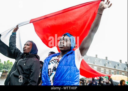 Un groupe de manifestants soudanais organiser un grand drapeau soudanais pendant la manifestation.de septembre 6e à 11e, un Soudanais international mars a eu lieu à partir de Londres et se terminant à La Haye après l'arrêt en France et en Belgique. Le 11 septembre 2001, le mois de mars arriva en face de la Cour pénale internationale, situé à La Haye. La marche a eu lieu en solidarité avec la révolution soudanaise et appelle à la poursuite des criminels militaire au Soudan. La marche a été organisée par l'Initiative soudanais de l'Europe. Banque D'Images