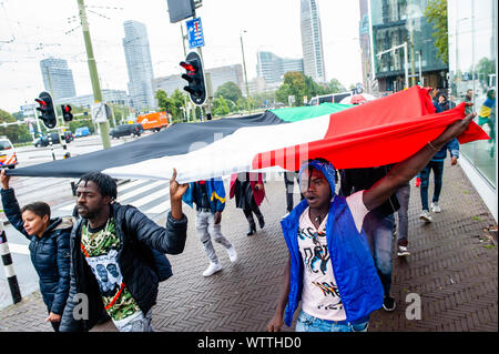 Un groupe de manifestants soudanais organiser un grand drapeau soudanais pendant la manifestation.de septembre 6e à 11e, un Soudanais international mars a eu lieu à partir de Londres et se terminant à La Haye après l'arrêt en France et en Belgique. Le 11 septembre 2001, le mois de mars arriva en face de la Cour pénale internationale, situé à La Haye. La marche a eu lieu en solidarité avec la révolution soudanaise et appelle à la poursuite des criminels militaire au Soudan. La marche a été organisée par l'Initiative soudanais de l'Europe. Banque D'Images