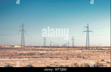 Rangées de pylônes de ligne à haute tension dans le désert Banque D'Images