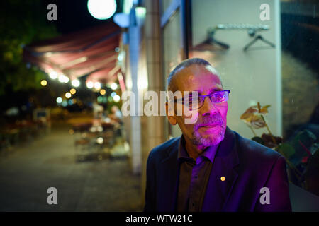 Berlin, Allemagne. 08Th Sep 2019. Peter-Christian Bürger, témoin contemporain et membre de la Bundesstiftung Aufarbeitung der dictature du SED, s'assied après une journée de travail sur un coin de rue dans le quartier berlinois de Friedrichshain. Son visage est éclairé par un néon. (Dpa-Histoire : 30 Ans Prague Ambassade) Credit : Gregor Fischer/dpa/Alamy Live News Banque D'Images