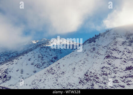 Pictersque paysage de montagnes de neige partiellement couvert par les nuages Banque D'Images