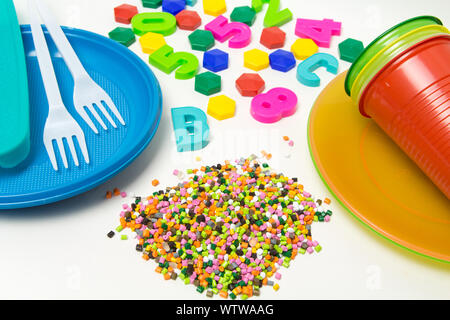 Vaisselle granules de plastique et les jouets fabriqués en polyéthylène, polypropylène, matériau polymère pet sur un fond blanc. Sans BPA Banque D'Images