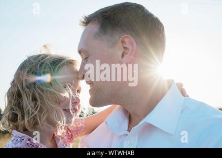 Portrait de père en portant sa fille dehors au coucher du soleil Banque D'Images