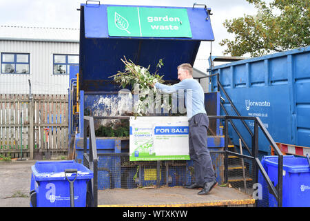 Homme portant des boutures de jardin pour le recyclage en compost au centre de recyclage de déchets ménagers Royaume-Uni Banque D'Images