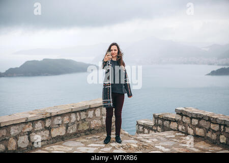 Une jeune fille ou d'un blogger prend des photos ou des enregistrements vidéos d'une vue sur la mer. Ou elle prend un. selfies Banque D'Images