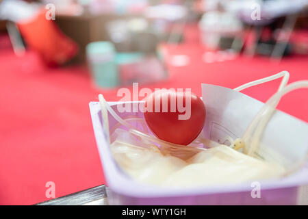 Un cœur rouge boule gonflable avec poche de sang dans le panier. Les soins de santé et de bienfaisance. Concept de don du sang Banque D'Images