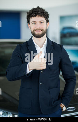 Vente, location d'auto, les gestes et les gens concept - smiling businessman showing Thumbs up sur l'arrière-plan de l'auto Banque D'Images