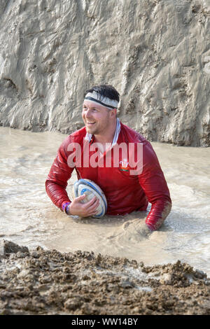 Un concurrent vêtu comme un pays de Galles rugby player sur le 'Mud kilomètre" à la dure épreuve d'endurance en Badminton Mudder Park, Gloucestershire UK Banque D'Images