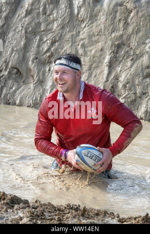 Un concurrent vêtu comme un pays de Galles rugby player sur le 'Mud kilomètre" à la dure épreuve d'endurance en Badminton Mudder Park, Gloucestershire UK Banque D'Images