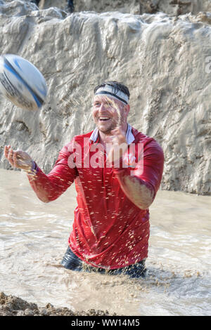 Un concurrent vêtu comme un pays de Galles rugby player sur le 'Mud kilomètre" à la dure épreuve d'endurance en Badminton Mudder Park, Gloucestershire UK Banque D'Images