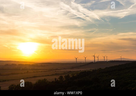 Coucher de soleil avec des moulins à vent et les traînées de près de Sopron, Hongrie Banque D'Images