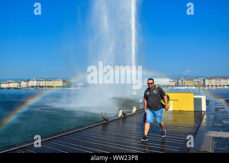 Tourist tournant au jet d'eau Fontaine à eau avec arc-en-ciel, belle attraction et symbole de Genève , Suisse Banque D'Images