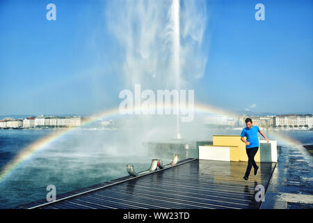 Tourist tournant au jet d'eau Fontaine à eau avec arc-en-ciel, belle attraction et symbole de Genève , Suisse Banque D'Images