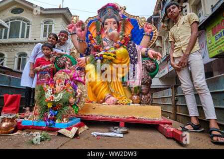 Au cours de la procession du Festival Ganesh à Mumbai, Inde, adorateurs de dieu éléphant Ganesh (Ganpati) monter sur un véhicule avec statues de Ganesh Banque D'Images