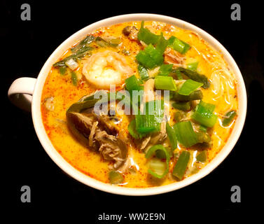 De savoureux fruits de mer asiatique soupe Laksa curry de crevettes, légumes, nouilles, tofu fèves germées dans un bouillon de noix de coco crémeuse épicée Banque D'Images