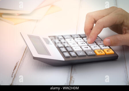 Femme d'affaires à l'aide d'une calculatrice sur le bureau, choisissez Focus point. Banque D'Images