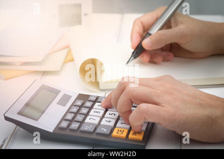 Part l'écriture et du calcul sur calculatrice de bureau Le bureau bois à propos de l'analyse des données financières, choisissez point focus. Banque D'Images