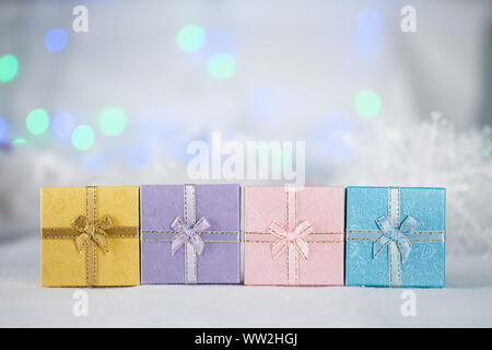Boîtes-cadeaux colorées sur la fourrure blanche, fond bokeh, avec espace de copie pour les salutations de saison, Joyeux noël ou Joyeux nouvel an.AF sélection de point, flou Banque D'Images