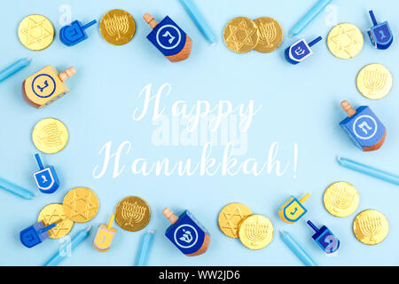 Fond bleu avec dreidels, menora bougies et pièces en chocolat avec Happy Hanukkah libellé. Hanouka et judaïque maison de concept. L'horizontale Banque D'Images