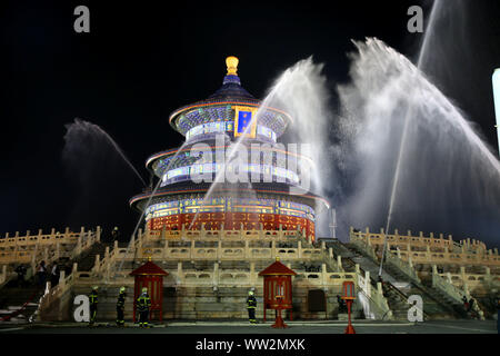 Les pompiers chinois de l'eau sur le flexible de salle de prière pour les bonnes récoltes au cours d'un exercice incendie au Temple du Ciel, Tiantan, également connu sous le nom de famille Banque D'Images