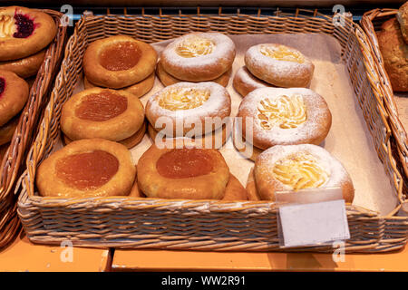 De délicieux gâteaux au fromage frais petits pains avec de la confiture et du fromage cottage sur le comptoir de bois dans la boulangerie. Banque D'Images