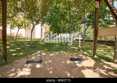 Vue d'un swing double vide au milieu de quelques arbres Banque D'Images