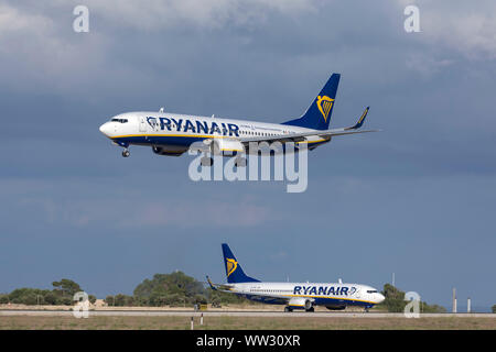 Ryanair Boeing 737-8AS (REG : EI-DWI) arrivant sur la terre tandis qu'un autre Ryanair 737 (EI-DHG) attend sur boucle Alpha pour le décollage. Banque D'Images