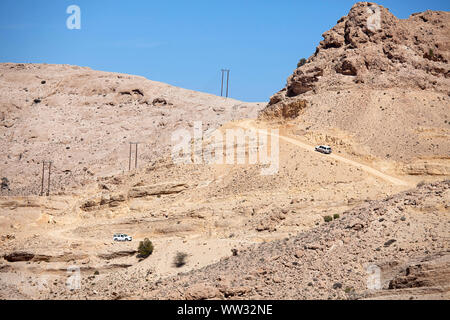 Deux voitures 4x4 de la conduite sur la route du désert de terre dans les montagnes de Jebel Akhdar, Oman Banque D'Images