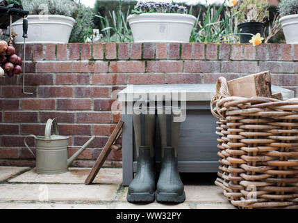 Une paire de bottes de pluie vert à l'extérieur dans un jardin de campagne anglaise Banque D'Images