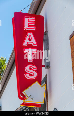Mange en néon avec la flèche pointant vers le bas, à l'Industrielle mange restaurant à Buellton, en Californie. Banque D'Images